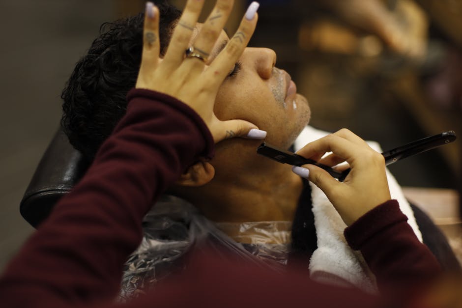 Professional barber performing precision haircut in luxury barbershop setting